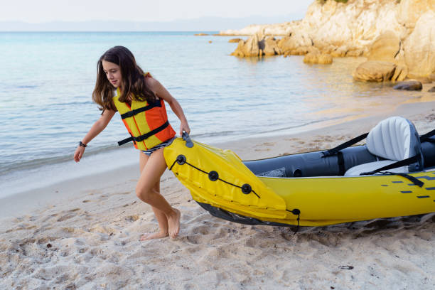 girl having fun with inflatable kayak on her summer cam vacation - summer camp child teenager kayak zdjęcia i obrazy z banku zdjęć