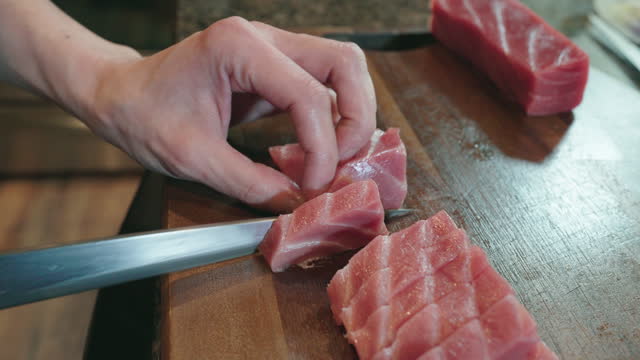 Sushi chef cuts tuna