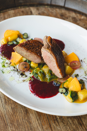 Food photography, delicious duck fillet on a large white plate. Restaurant, banquet, catering.
