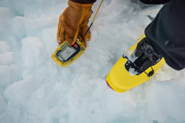 Person holding a modern avalanche beacon in his hands. Off piste skier displaying avalanche beacon and how to use it. Lavine prevention device, beacon to find a person gliding on snow. Person holding a modern avalanche beacon in his hands. Off piste skier displaying avalanche beacon and how to use it. Lavine prevention device, beacon to find a person gliding on snow. avalanche beacon stock pictures, royalty-free photos & images