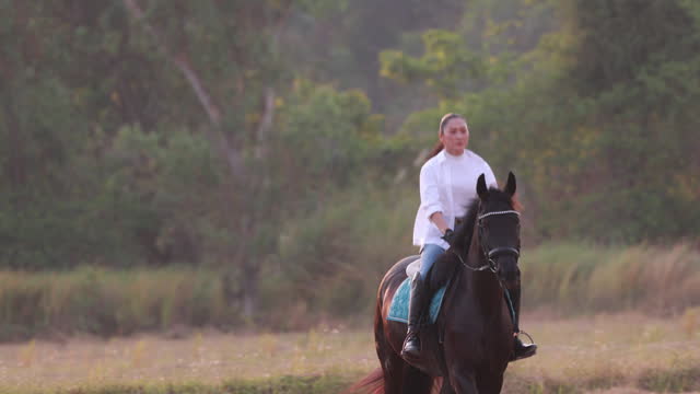 Rural Adventure: Asian Female Embarking on Horseback Riding Adventure Amidst Scenic Farm Landscape | Outdoor Leisure Activity