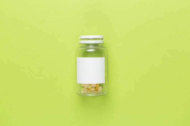 Plastic bottle with vitamins on color background, top view