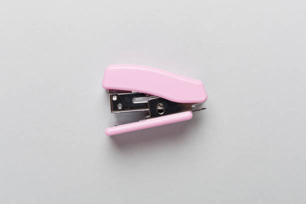 Pink stapler on color backgroung, top view