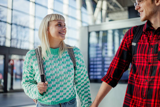 istock A happy couple is holding hands and walking at train station. 2011490606