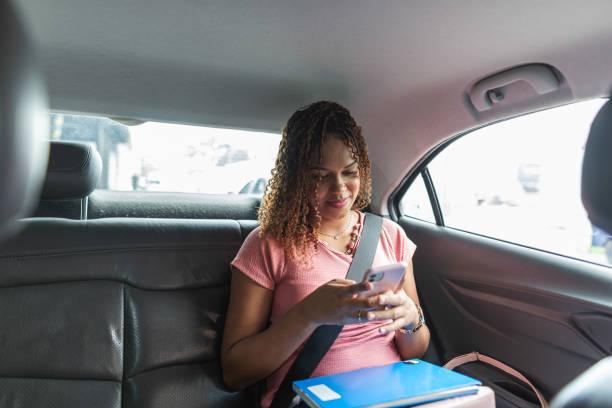 istock Female passenger using smartphone in the backseat of a car 2011500637