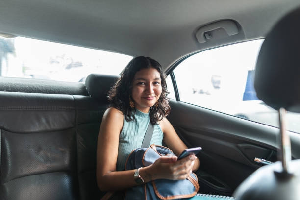istock Female passenger using smartphone in the backseat of a car 2011502165