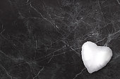 White heart balloon on a black marble background