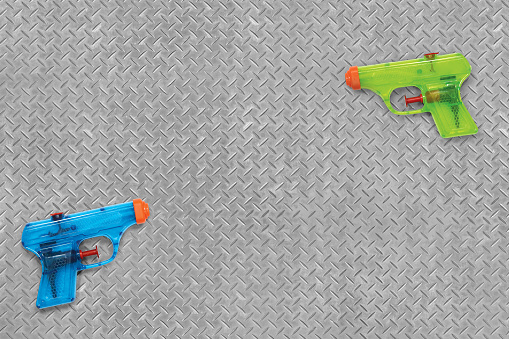 Plastic water squirt guns on an industrial background