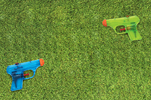 Plastic water squirt guns on a grass lawn