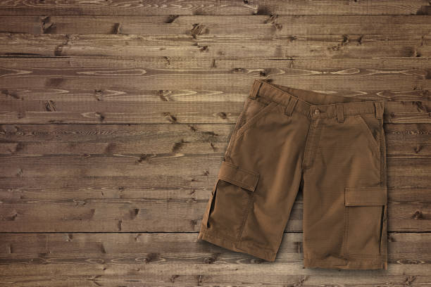 istock Brown cargo shorts on a wood background 2011506505