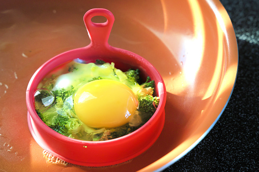 Egg roasted with broccoli in silicone mold on a ceramic frying pan, healhty homemade breakfast