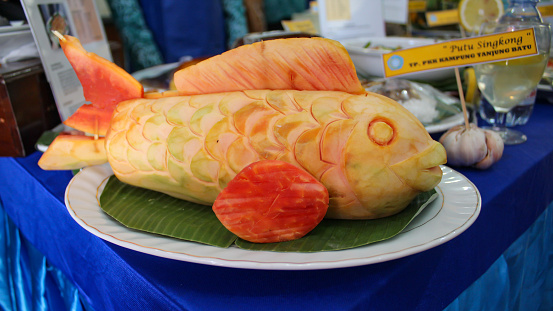 Papaya is carved and shaped like a fish. Fruit and vegetable carving decoration.