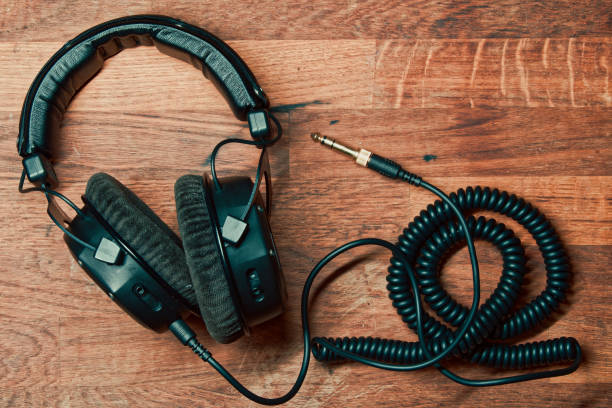 istock Professional studio headphones with a coiled cable on a wooden surface 2011630038