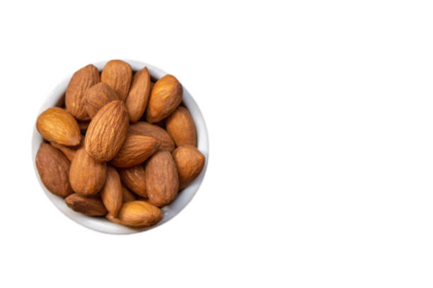 Almonds in a bowl on a white background, with copy space.