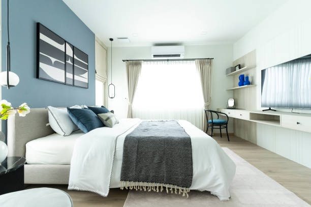 istock Stylish Bedroom with gray fabric headboard and bed with soft blue and white pillows 2011729503