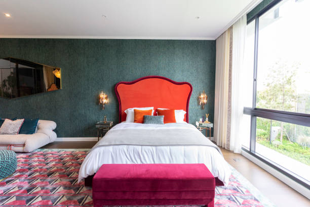 istock Modern luxurious red tone bed with crystal wall lamp in interior. 2011731570
