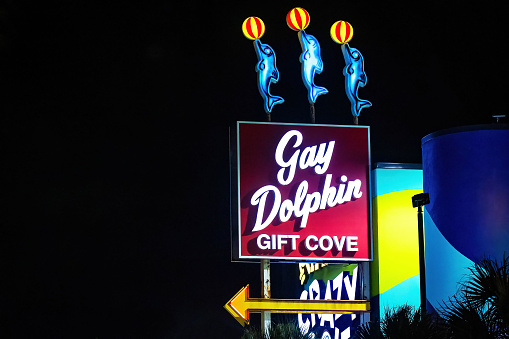 Myrtle Beach, SC, USA - 12-26-2023: Gay Dolphin Gift store illuminated sign at night