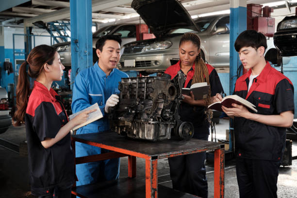 istock Supervisor engineer is teaching mechanic workers about car engines at a garage. 2011755260