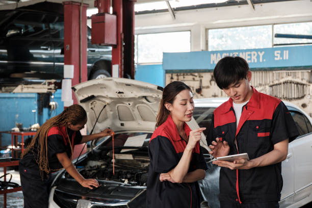 istock Two Asian professional automotive mechanics working at a service garage. 2011756309