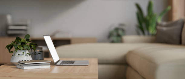 istock A laptop computer on a wooden coffee table in a modern and comfortable living room. side view 2011762743