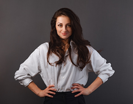 Beautiful business toothy smiling woman with long brown healthy hair style standing with folded arms in white stripped shirt. Healthy lifestyle and success business. Closeup front portrait with empty copy space