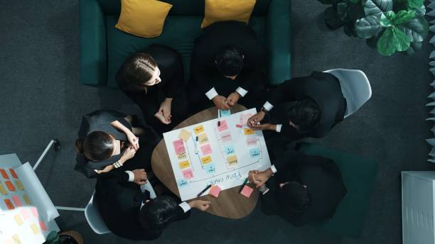 istock Close up of team writing and putting sticky note on task board. Directorate. 2011823151
