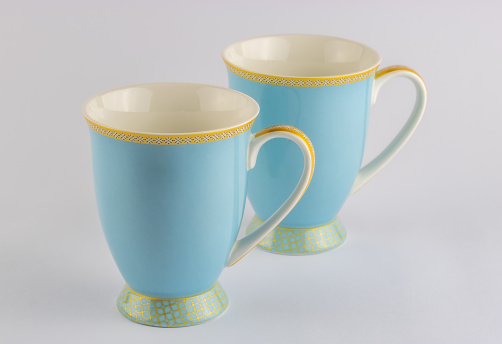 Two blue and gold tea or coffee cups isolated on white background