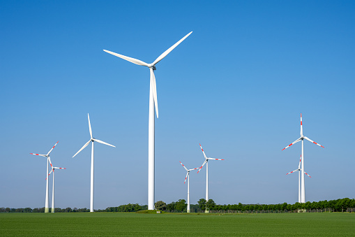 Modern wind turbines in front of a blue sky seen in rural Germany