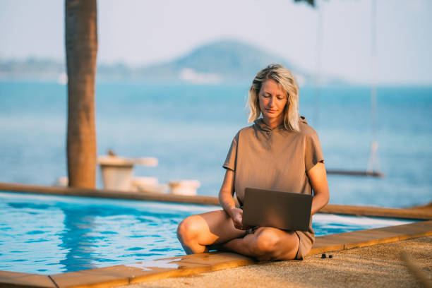 istock A woman works remotely by the pool 2011907130