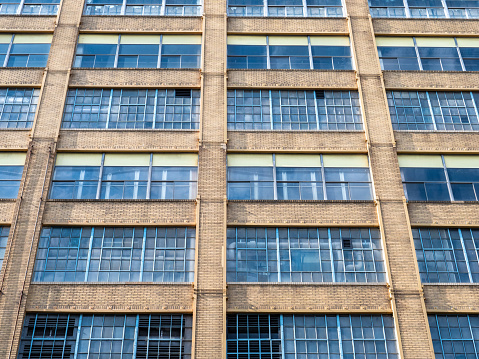 An Old Historic Factory With Large Windows and A Brick Facade With Multiple Stories