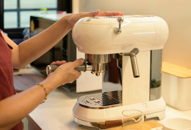 istock Female preparing fresh coffee while using modern coffee maker in the kitchen at home 2011943951