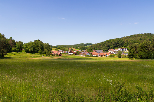 Rural scene with hill panorama, meadows and houses of village Bärnfels near Obertrubach in Franconian Switzerland, Germany