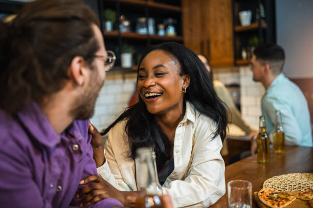 istock Young friends laughing together during a dinner together in a friend's kitchen 2011973540