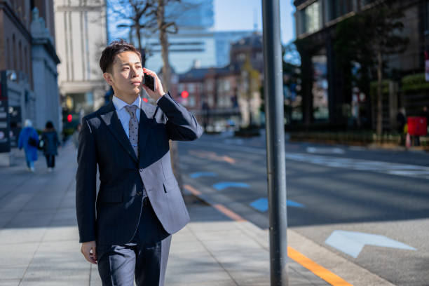 istock walking businessman with phone 2012015990