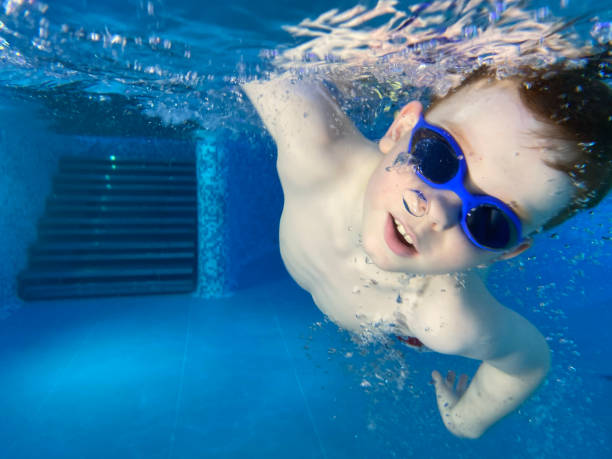 a boy swimming underwater in the pool - mobilestock freedom enjoyment blue - fotografias e filmes do acervo