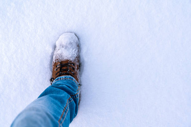 istock Warm winter shoe steps into a fresh blanket of snow with text space 2012044632