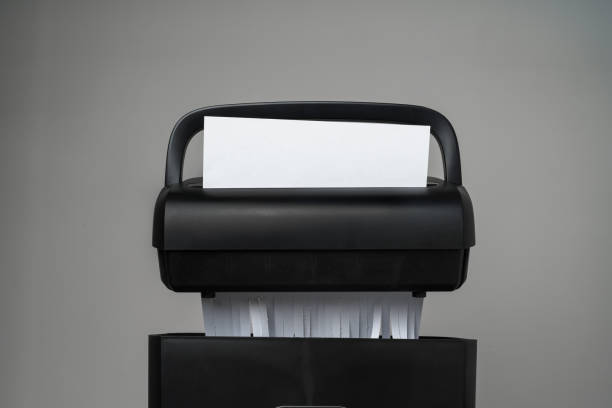 istock Black paper shredder cutting paper on gray background 2012057546