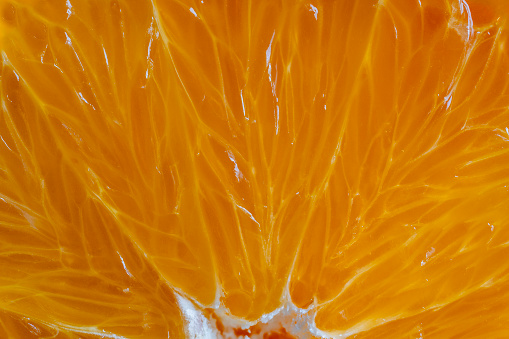 Close up of sliced ripe orange, macro. Yellow fresh orange surface background or texture. Top view