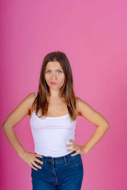 istock Playful woman with hands on hips, pink backdrop. 2012093276