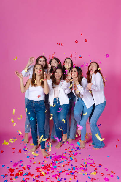 istock Joyous friends partying with confetti, pink background. 2012095855