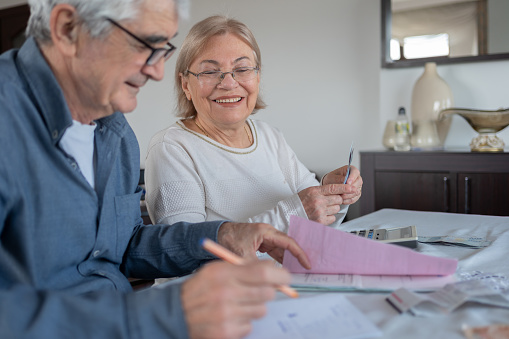 Senior Couple Calculating Bills And Expenses At Home