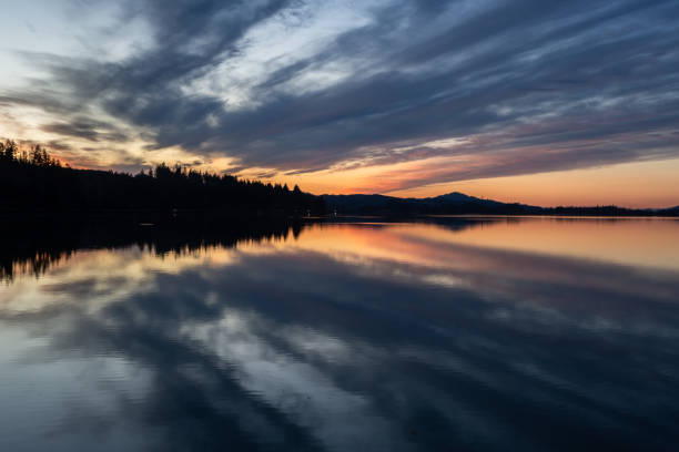 istock Sunset glow over a lake reflecting in calm water 2012132102