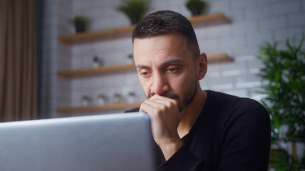 istock Man sit in kitchen using laptop watching video, surfing internet, using social media, chatting with friends. Medium close-up 2012137317