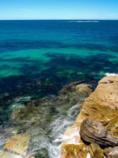 istock Powerful white swirling waves (blurred motion) crashing into coastline rocks 2012147848