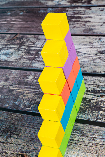 Multicolored blocks stacked vertically on a table