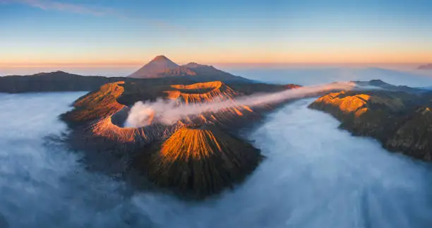 Aerial view of Bromo in beautiful sunrise with low fog during eruption