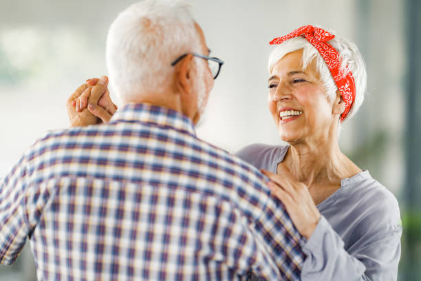Happy senior couple having fun while holding hands and dancing on a party.