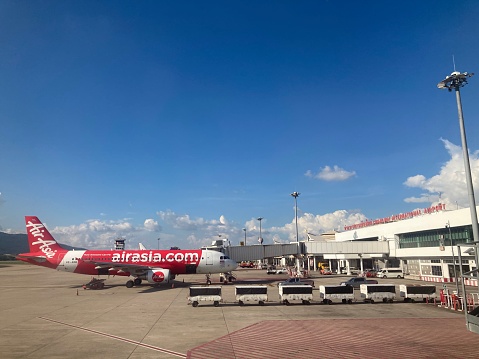 Chiang Mai, Thailand – June 10, 2020: An AirAsia airline company plane is parked on the runway waiting to pick up passengers at Chiang Mai International Airport, Chiang Mai, Thailand