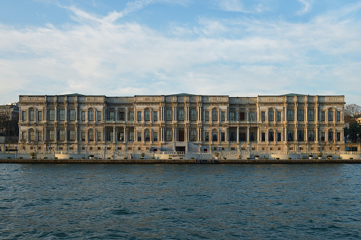 Istanbul, Turkey - December 10, 2023: Ciragan Palace Kempinski. Ottoman imperial palace and luxury 5-star hotel on Bosphorus. View of Palace from Bosphorus Strait at sunset