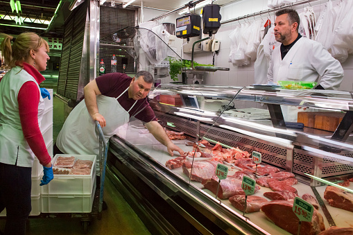 Horizontal view of a butcher’s stall in the old Abaceria Central Market of the Gracia neighborhood in Barcelona
